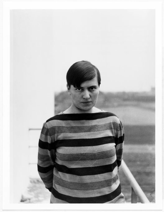 Black and white portrait of Marianne Brandt, Bauhaus designer, wearing a striped sweater with a serious expression, circa 1920s–1930s.