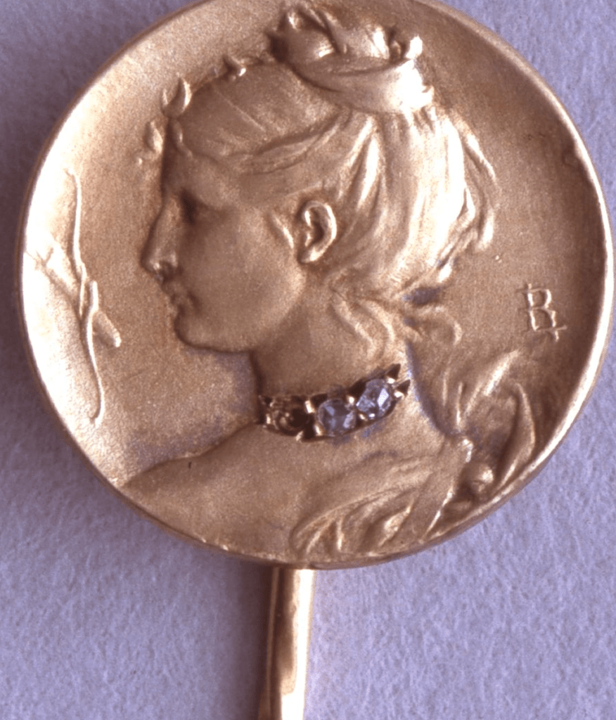 Gold cravat-pin with a medallion struck in gold with a profile of Diana with a crescent, bow & arrow to the left by Louis Armand Rault