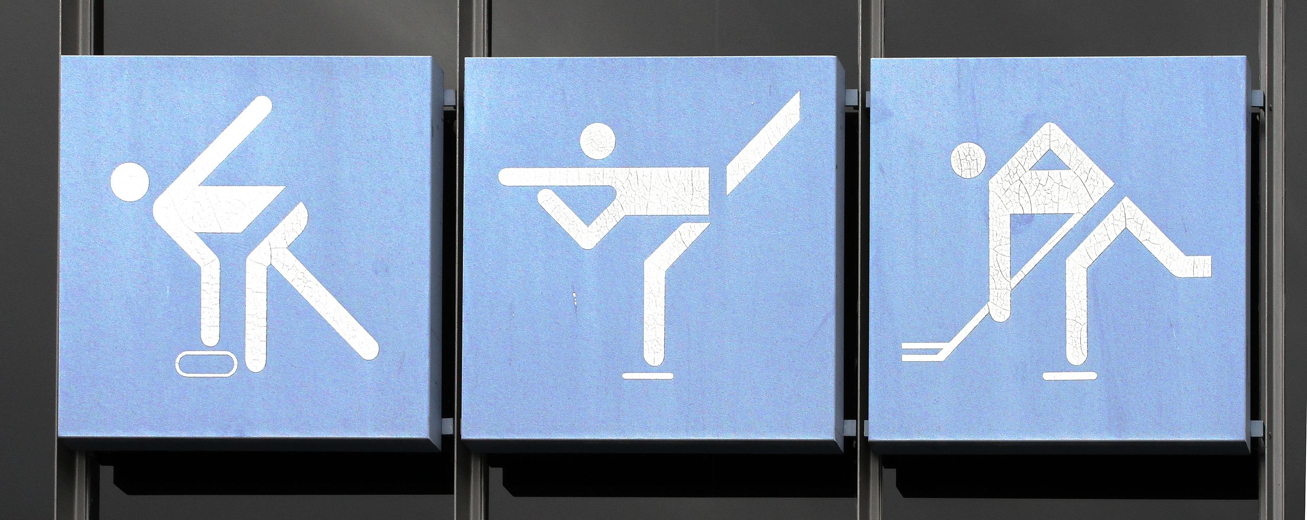Three minimalist pictograms designed by Otl Aicher for the 1972 Munich Olympics, representing curling, figure skating, and ice hockey.