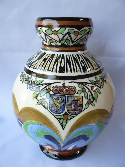 and-painted Amstelhoek ceramic vase with intricate floral patterns and a royal crest.