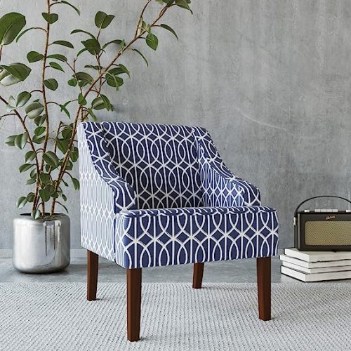 A HomePop Velvet Swoop Arm Living Room Chair featuring a navy blue and white geometric patterned fabric with dark wooden legs.