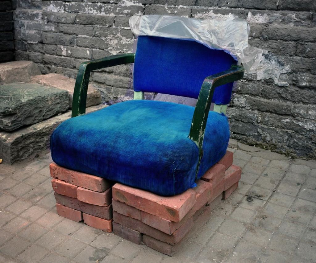 Wild design is perhaps one of the most overlooked aspects of modern urban life, particularly in China. While it lacks the glamour of haute couture or the finesse of artisanal craftsmanship, wild design stands as a testament to human ingenuity, resourcefulness, and adaptability. It challenges us to question our understanding of design itself: its function, aesthetics, and the narratives that shape it. The Artists and their Explorations Artists like Michael Wolf, Bill Aitchison, Huang Heshan, and Chu Jini have peeled back the layers of wild design in China, revealing a previously unexplored facet of urban life. Michael Wolf's series 'Bastard Chairs' and 'Back Door' expose how everyday objects like chairs, stools, and even makeshift temples are being patched up and reconfigured multiple times. This form of design, born out of necessity, is a reflection of the thriftiness and ingenuity of the Chinese people (Liu, 2023). Bill Aitchison's 'China Quick-Fix' blog delves deeper into this phenomenon. He defines the quick fix as a "short-term solution to a problem that does not solve the cause of the problem, but rather, treats its symptoms." His exploration highlights the use of rudimentary materials like plastic bottles, tape, and cardboard, providing a rare and humane insight into the challenges ordinary people face (Liu, 2023). Characteristics of Wild Design Huang Heshan takes this study a step further. In his research, he outlines five key traits that define wild design: it is mundane, brutal, cheap, easy, and pragmatic. These designs are typically seen among migrant populations in cities like Beijing, Guangzhou, Shanghai, and Shenzhen. They are a consequence of congested living conditions and limited resources (Liu, 2023). Chu Jini, on the other hand, focuses on the DIY structures that serve multiple urban needs, from roadblocks to signage. These forms of design are ever-evolving, changing in form and function to adapt to the complex, ever-shifting urban fabric (Liu, 2023). Social Impact and Relevance The birthplaces of wild design—migrant villages—are rapidly evolving spaces. Over time, these makeshift solutions have come to challenge and destabilize existing social and material structures, shedding light on the relationship between design and infrastructure (Liu, 2023). Despite the immense practicality and social relevance, wild design is often mischaracterized as a mere aesthetic style. This is a critical mistake. Wild design serves as an act of rebellion against the monopolistic infrastructures that fail to address the basic needs of ordinary people. It speaks volumes about the social fabric, revealing the hidden links among various actors in broader socio-cultural networks. Summation and Future Directions Coined by Huang Heshan, wild design is a phenomenon that essentially epitomizes the practice of using minimal materials to satisfy enormous social needs. As an ongoing project, the growing visual archives of wild design captured and shared by ordinary people are helping to further diversify the interpretations and implications of these spontaneous solutions (Liu, 2023). The aim is to extend this dialogue through more animated interpretations and narratives that lend a sense of humor and humanity to these designs. After all, if design is to be understood as a solution to human problems, then wild design stands as one of its purest forms (Liu, 2023). By understanding and appreciating the significance of wild design, we not only honor the unnamed designers behind these creations but also contribute to a more inclusive, realistic narrative of what design can and should be. So the next time you stumble upon a chair held together by duct tape or a cardboard sign directing traffic, take a moment to appreciate this wild side of design—it's a field study in resilience, creativity, and the very human act of making do. References Yaxi Liu (2023). Wild design and its activism in everyday urban life, The Design Journal, 26:3, 417-437.