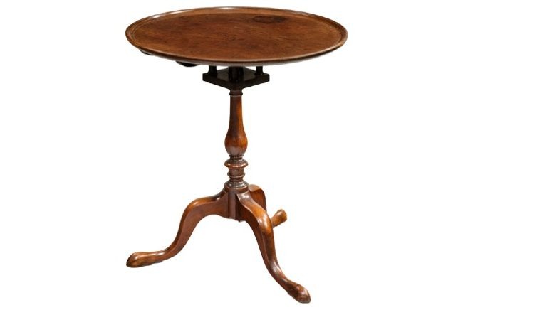 18th-century wooden pedestal table with a circular top and tripod base, featuring elegant curves and a polished finish.