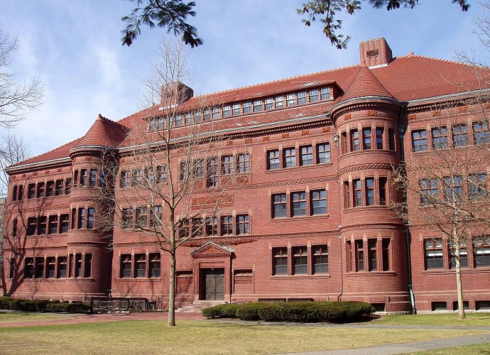 Sever Hall at Harvard University, designed by Henry Hobson Richardson, showcasing Richardsonian Romanesque architecture with red brickwork, arched windows, and rounded turrets.