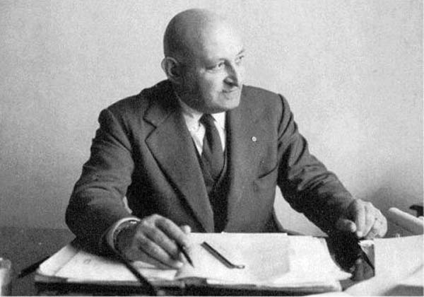 Corradino d’Ascanio seated at a desk, Italian aeronautical engineer and industrial designer, photographed at the University of Pisa.