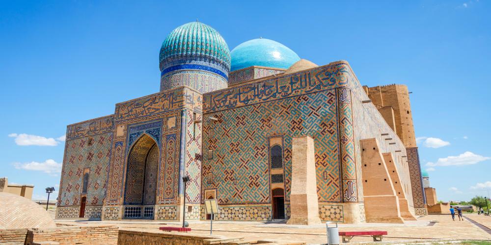 Mausoleum of Khoja Ahmed Yasawi in Turkistan, Kazakhstan, featuring turquoise domes, geometric tilework, and Arabic calligraphic inscriptions integrated into the architectural façade.