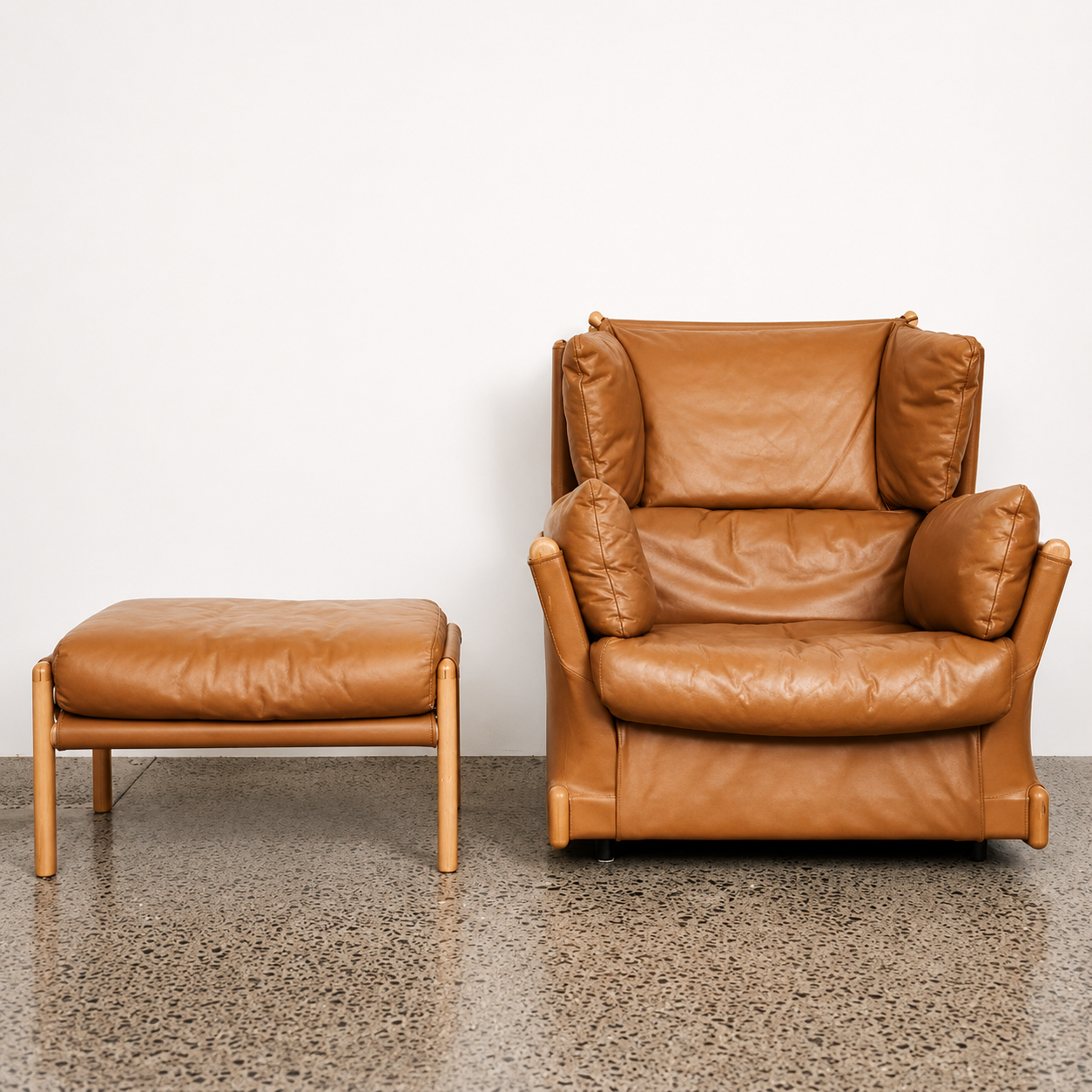 Piero De Martini Viola d’Amore armchair with matching footstool, designed circa 1970 and manufactured by Cassina with tan leather upholstery.